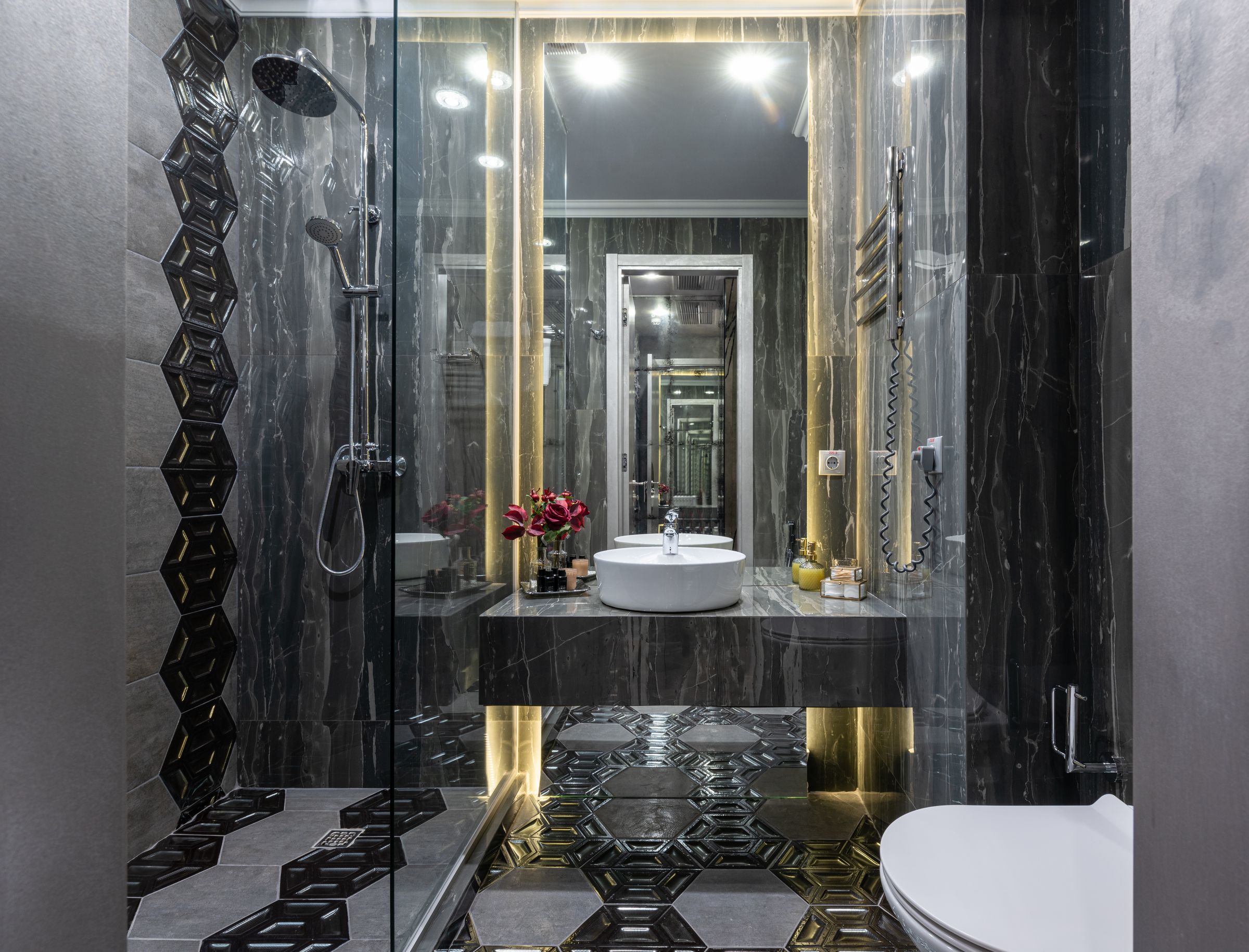 Badezimmer mit rahmenloser Glasdusche von Sentido Interiors